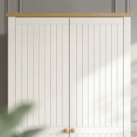[White] Linra 2 Door Wardrobe upper section close-up showing vertical grooved door panels, oak effect top edge, and round oak knobs