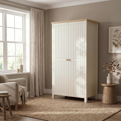 [White] 2 door linra wardrobe in a room beside chair, and small table and with natural light coming from the window