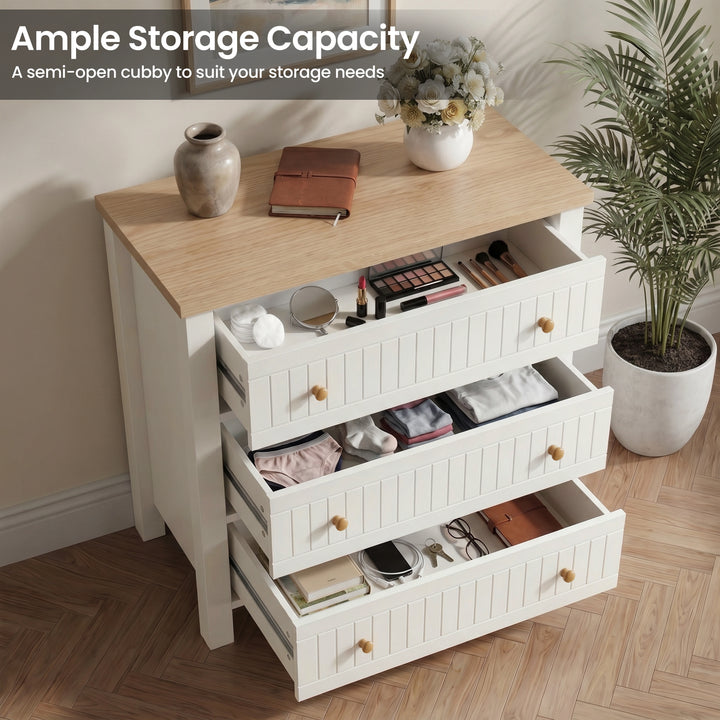 [White] dresser with multiple drawers containing various items, placed in a room with a plant and decor