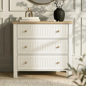 [White] Linra chest of drawers front view with oak top styled with vase, blossom stems, books in sunlight