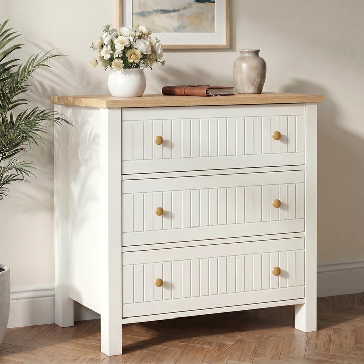 [White] dresser with wooden top in a room setting with decor items