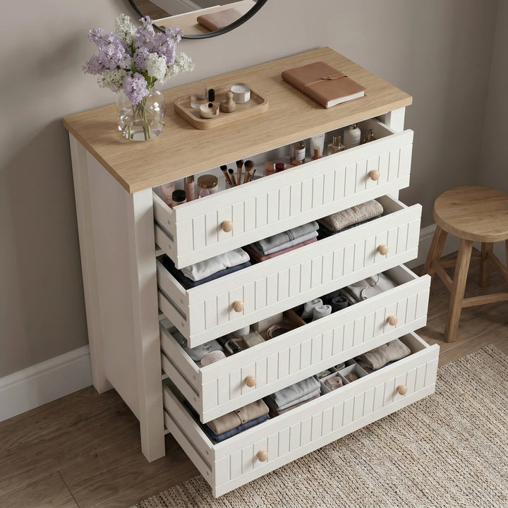 [White] Linra 4 drawer chest with all four drawers open at an angle revealing stored accessories, folded clothes, and jewellery in bedroom setting