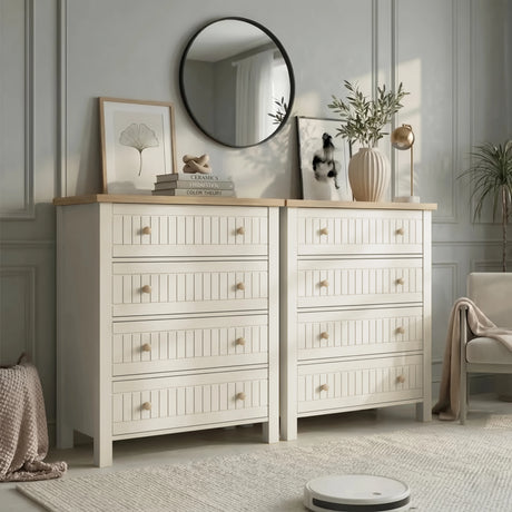 [White] Linra 4 drawer chest shown as a matching pair side by side with prints, olive branch vase, and art books on oak tops in living space
