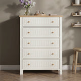 [White] Linra tall 5 drawer chest front view against dark wall with oak top styled with pale vase, dried palm, and brass candle tray