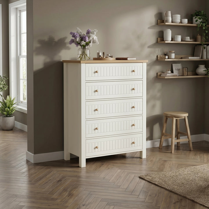 [White] Linra tall 5 drawer chest in a styled living space against a grey wall with a stool on wooden floor