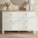 [White] Linra large 6 drawer chest front view against a beige wall room, oak top with lamp and stems