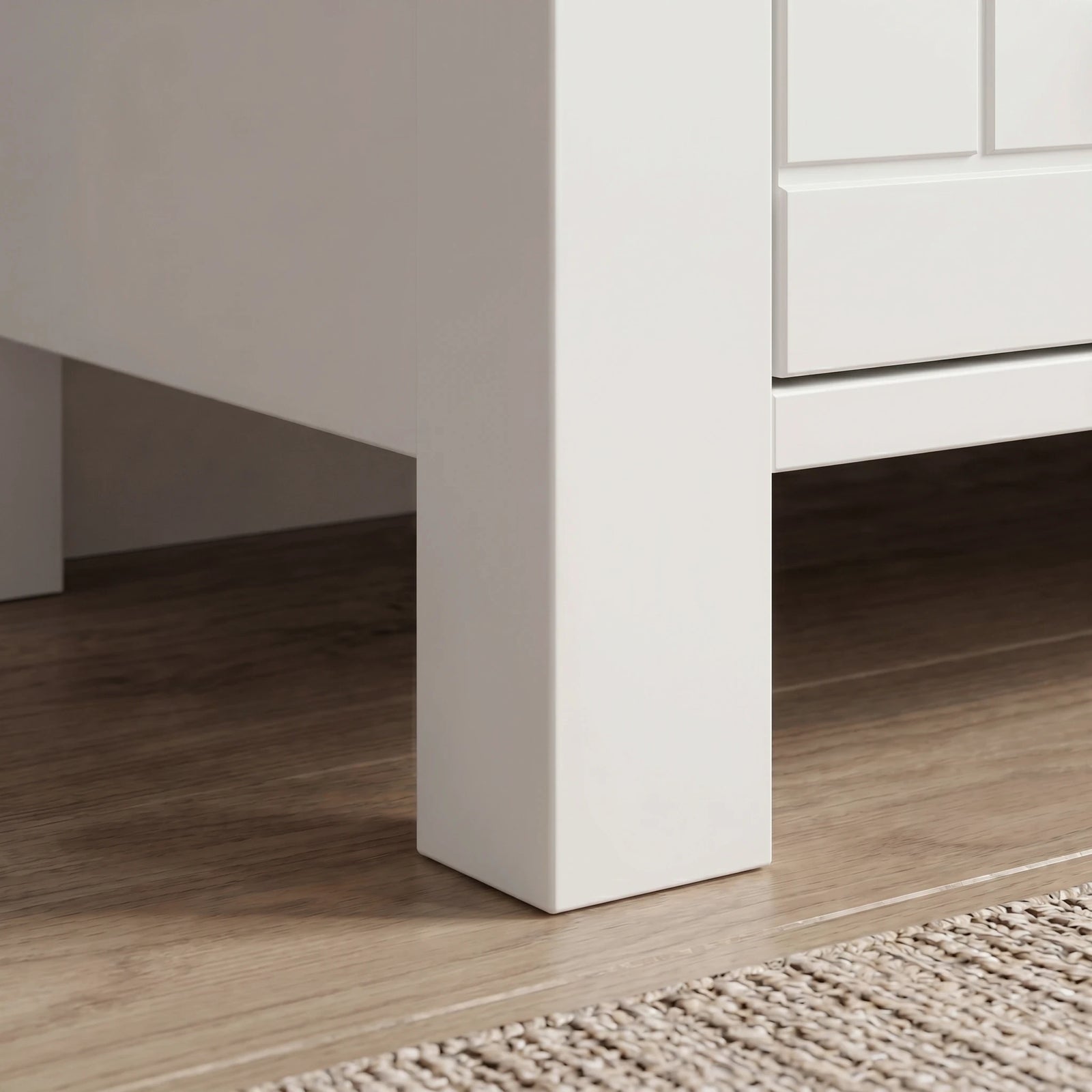 [White] Linra large 6 drawer chest base detail, tapered white leg lifting cabinet above oak flooring