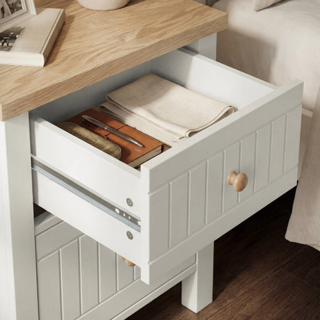 [White] Linra bedside table in white oak finish with open drawer highlighting ample storage capacity and painted knobs bar handle design