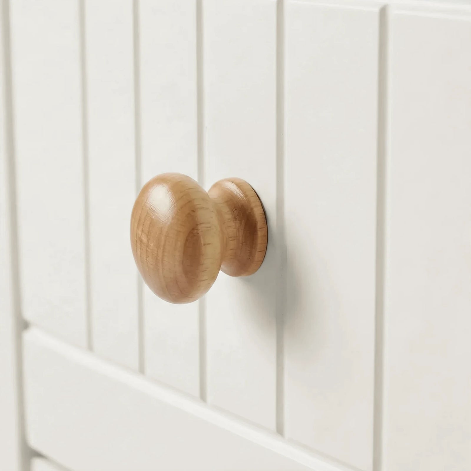 [White] Linra chest of drawers close-up of natural oak rounded wooden knob on grooved painted drawer front