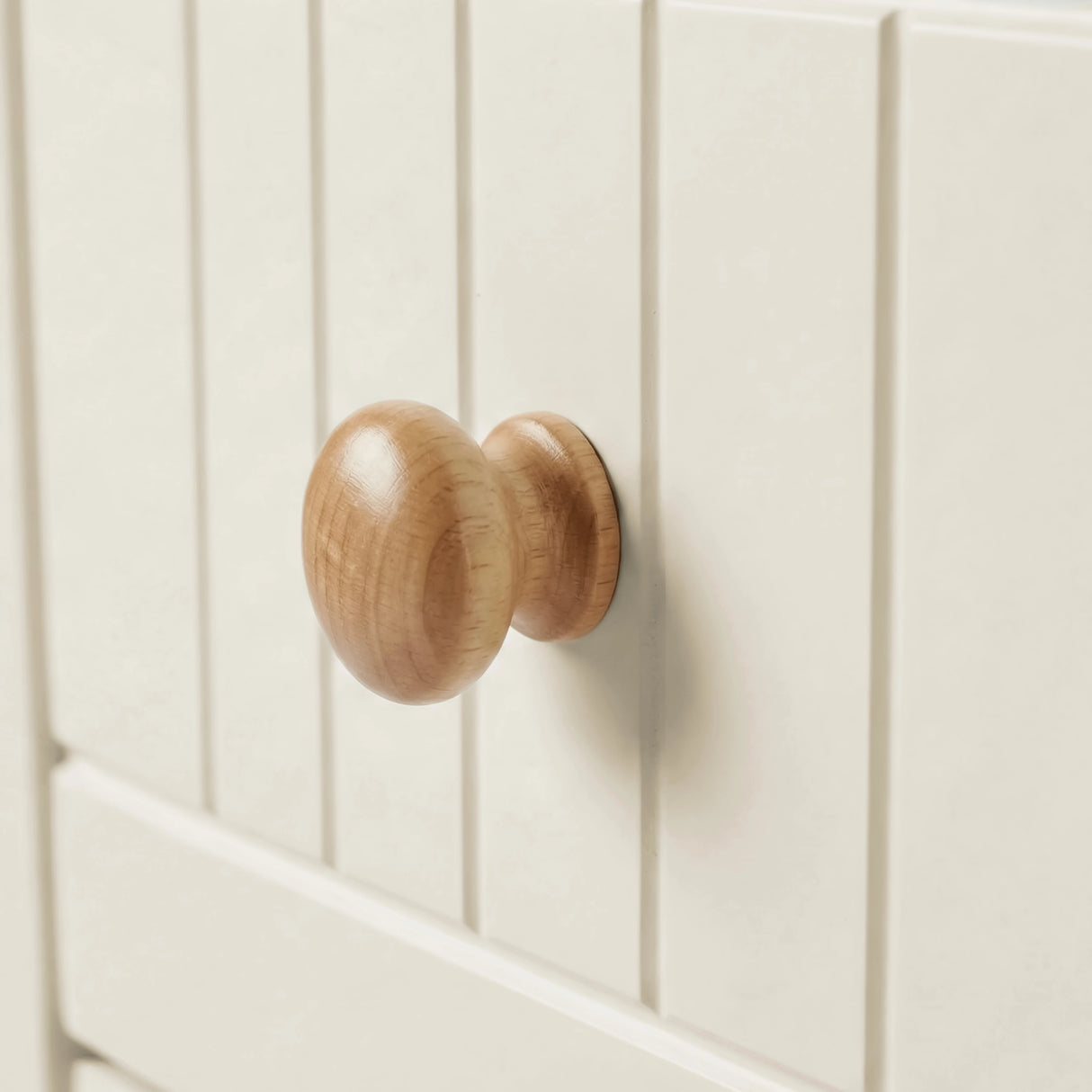 [White] Linra chest of drawers close-up of natural oak rounded wooden knob on grooved painted drawer front