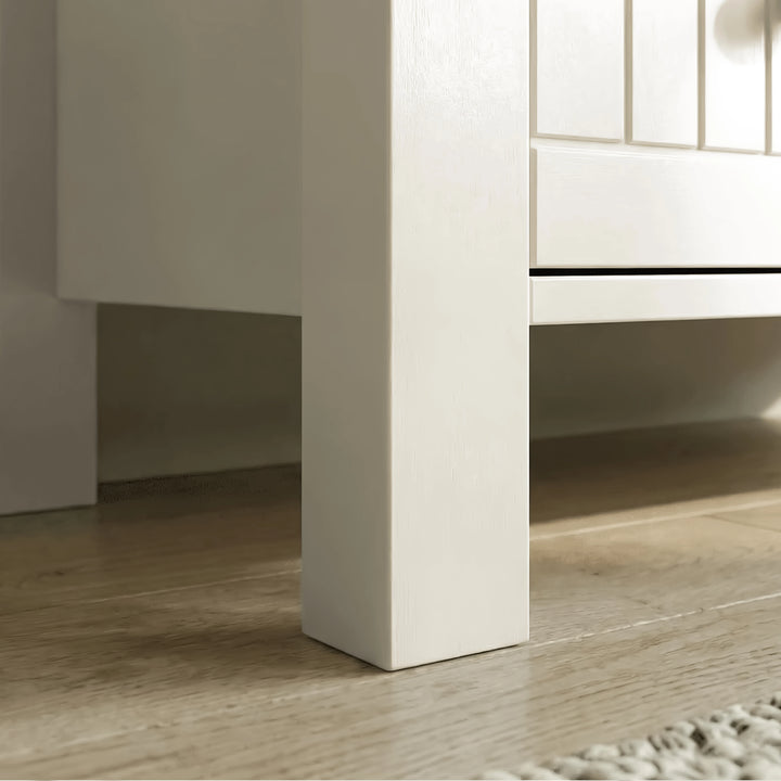 [White] Linra chest of drawers leg detail showing white painted post meeting drawer rail and floor