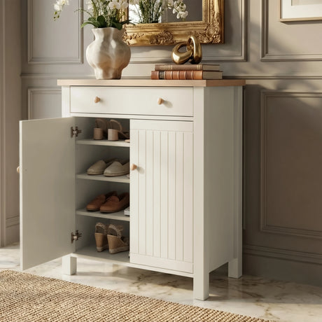 [White] Linra shoe cabinet with one door open revealing four shelves holding heels and espadrilles beside gold mirror and orchid vase in hallway