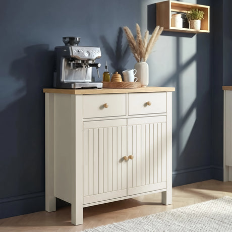 [White] Linra sideboard styled as a kitchen coffee station with espresso machine, wicker tray, and botanical wall shelf in morning light