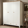 [White] Linra wardrobe angled closed view with beaded doors, lower drawers, oak top, curtain, framed art, vase, and stool.