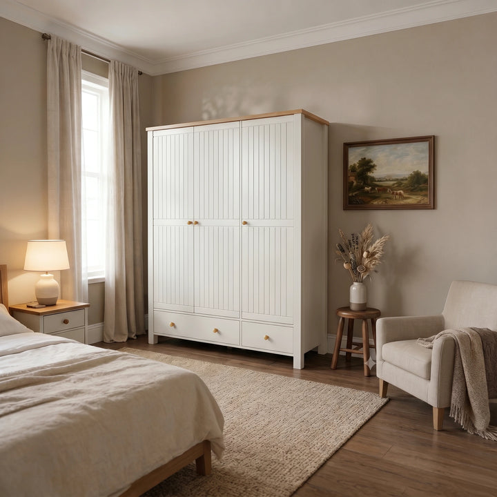 [White] Linra wardrobe in bedroom with closed panel doors, lower drawers, oak top, window, lamp, chair, vase, and wall art.