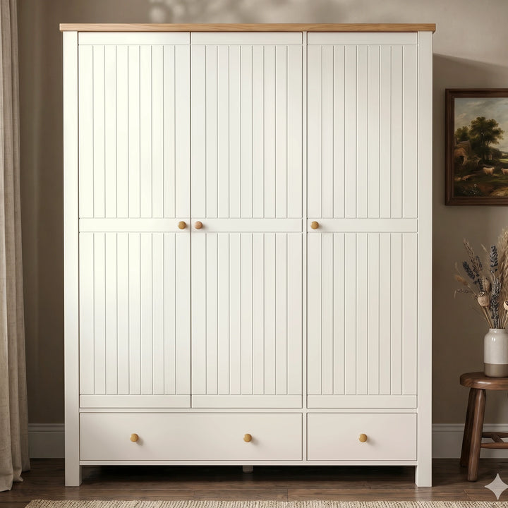 [White] Linra wardrobe straight front view with three closed doors, lower drawers, oak top, wooden knobs, vase, and wall art.