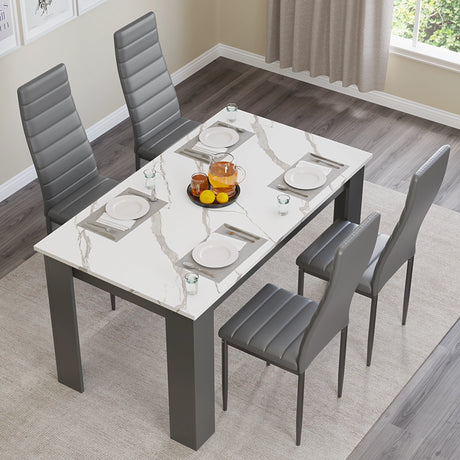 a top view of a modern dining table with chairs in white marble finish and grey upholstered seating