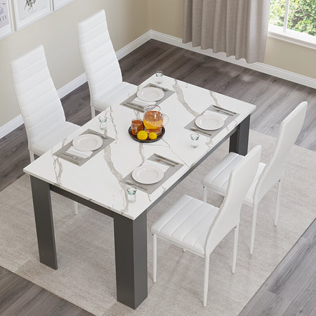 overhead shot of dining table and 4 chairs with white marble top, styled with plates and white seats