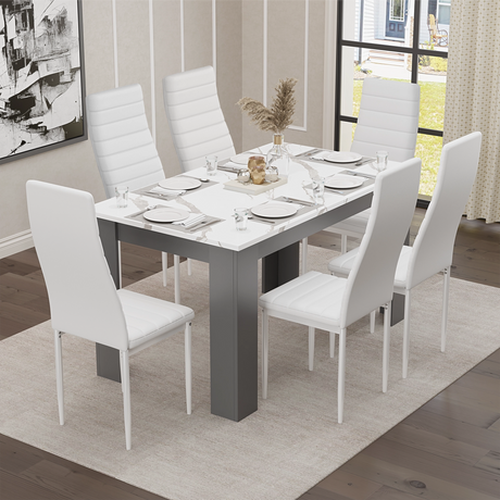 white marble dining room table with grey legs, styled with neutral decor and grey upholstered chairs