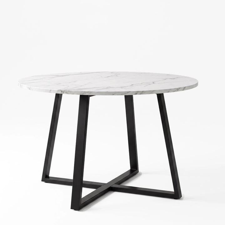 [White Marble] Round marble-effect dining table in a studio view with the tabletop resting on a black iron cross base.
