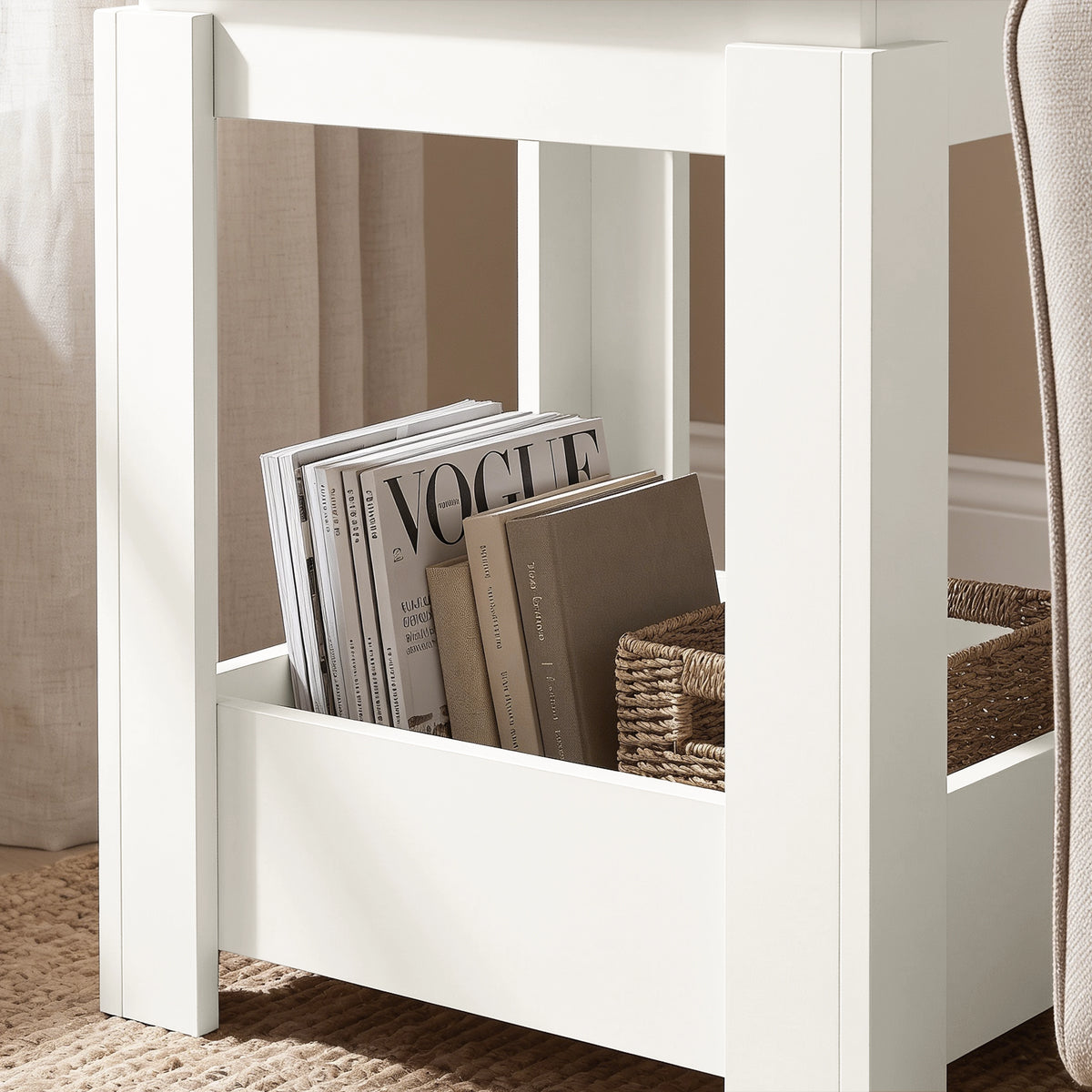 [White] Close-up of the square side table's open lower storage holding books and a wicker basket