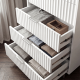 White flutrina chest of drawers with multiple drawers extended to display internal storage capacity
