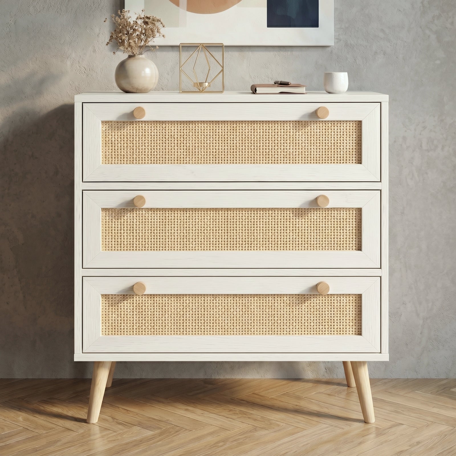 [White] Rattan three-drawer chest photographed straight-on, showing dual wooden knobs and full rattan panel detail