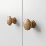 [White] Selby wardrobe close-up of two round natural wood door knobs on white flat door panels