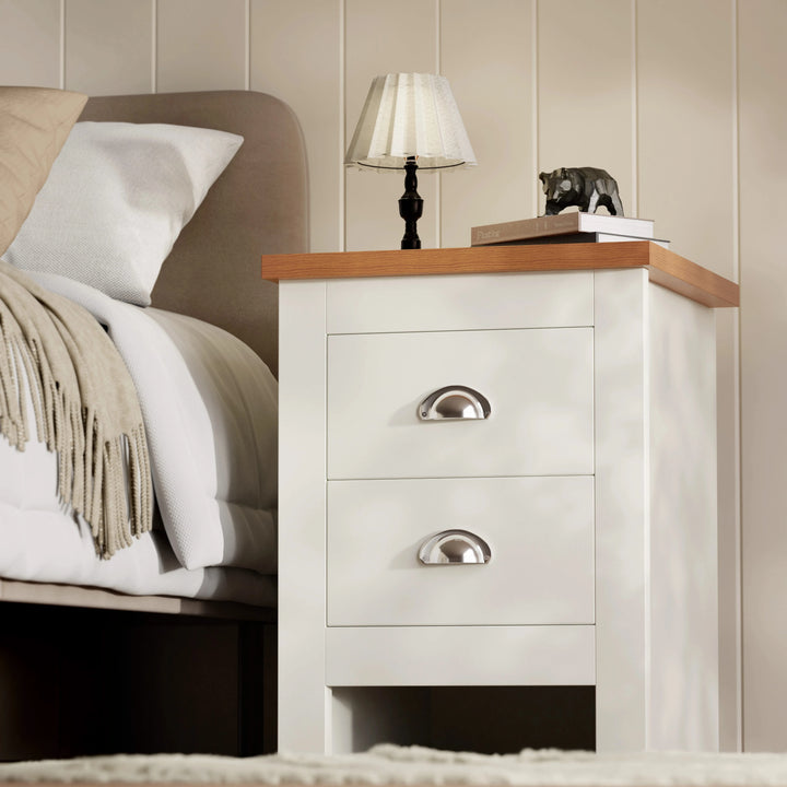 [White] white shaker 2 drawer bedside table side angle with throw on bed and panelled wall behind