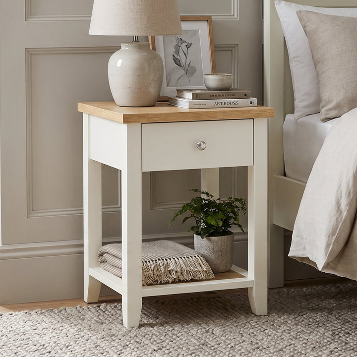 [White] Angled view of the White Shaker Bedside Table with natural oak top, single drawer, and open shelf.