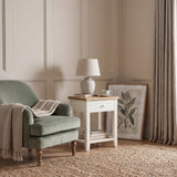 [White] White Shaker Bedside Table placed next to an armchair in a cozy reading corner setup.