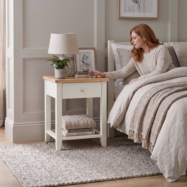 [White] Lifestyle view of the White Shaker Bedside Table styled beside a modern upholstered bed.
