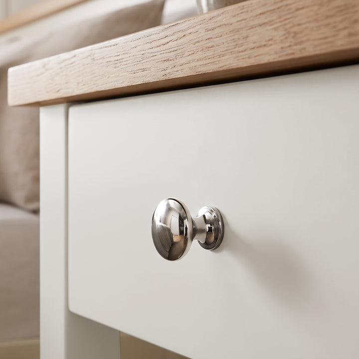 [White] Close-up detail of the polished silver round knob on the White Shaker Bedside Table drawer.