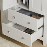 close-up of white shaker wardrobe drawers with metal handles, showing storage for clothes and accessories