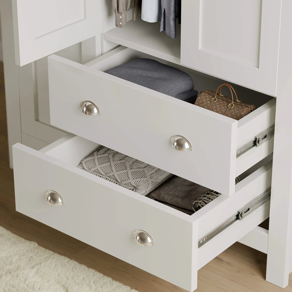 [White] close-up of white shaker wardrobe drawers with metal handles, showing storage for clothes and accessories