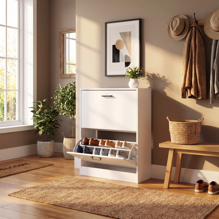 [White] modern shoe cabinet with an open lower compartment displaying shoes, placed in a styled entryway with a bench, basket, framed wall art, plants, and a window.