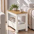 [White] Angled side table view showing a leafy plant and mug on the wood-effect top, with books in the lower compartments.