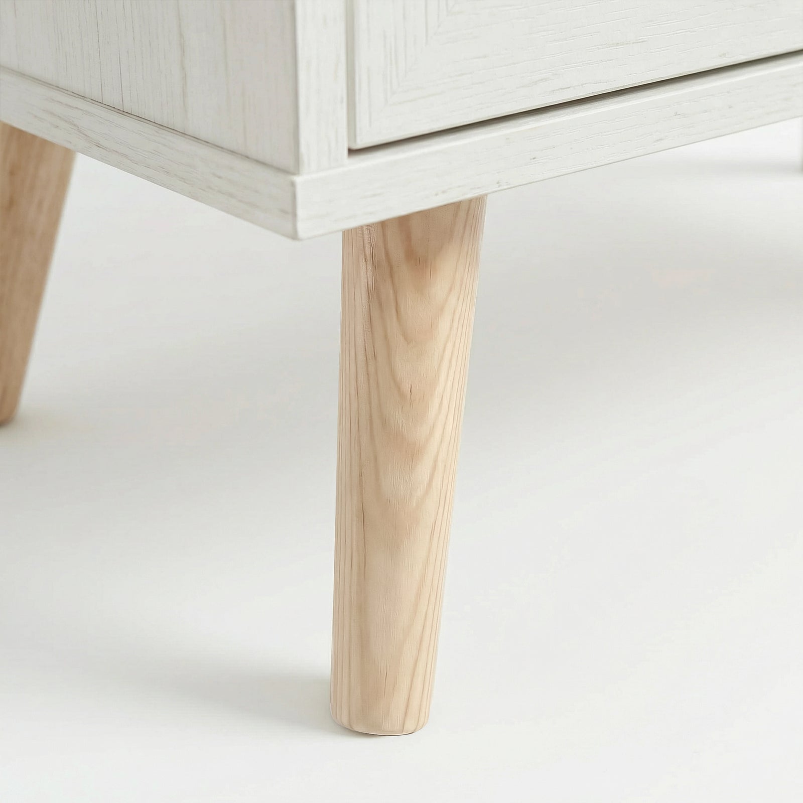 [White] Wovena Rattan 3 Door Sideboard - Adjustable Shelf White close-up detail of the splayed, tapered light wooden legs.