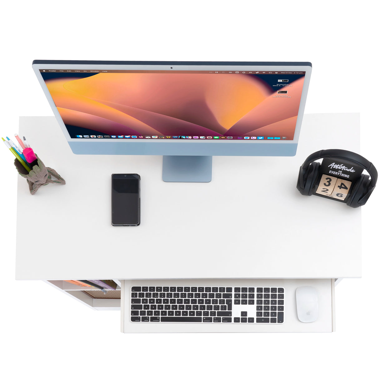 top view of a cheap computer desk in white showing an extended tray, monitor, phone, and accessories for budget home offices
