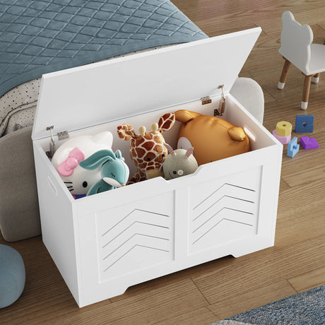 Storage Chest - Wooden Box With Lid For Blankets, Clothes or Toys in white finish, open and filled with plush toys beside a bed in a kids' room.