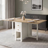 [White] Stovra Drop Leaf Dining Table fully extended with four place settings in a sage green dining room