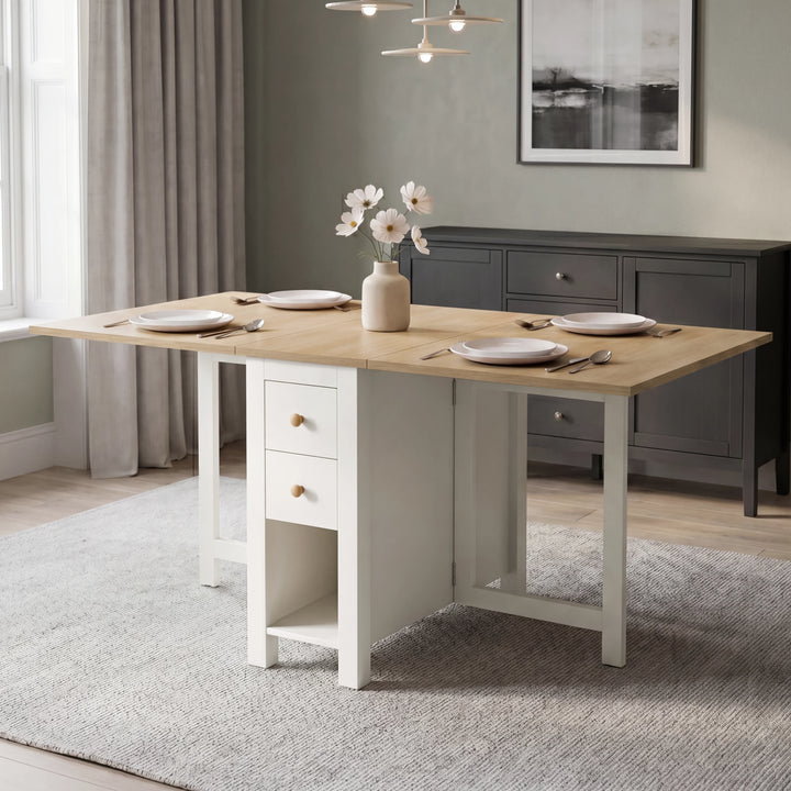 [White] Stovra Drop Leaf Dining Table fully extended with four place settings in a green dining room