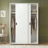[White] White wardrobe with clothes in a room with green walls and a small table with flowers.