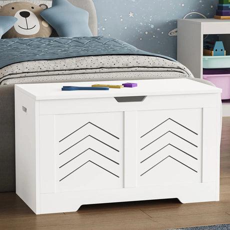White toy storage with geometric design in a child's bedroom with toys and a teddy bear.