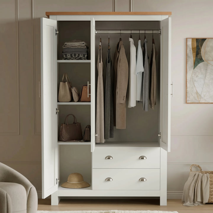 [White] Shaker Triple Wardrobe With Drawers And Shelves open showing clothing hanging on the rail and shelving.