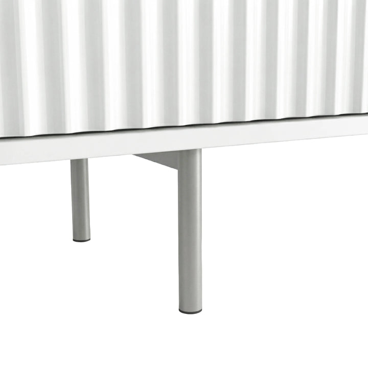 [White] Chrome leg hardware shot on white Flutrina TV unit, fluted door bottom edge visible above leg.