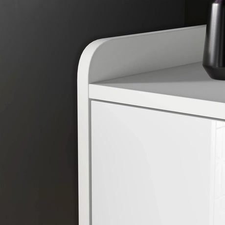 White cabinet with a black vase on a dark wall