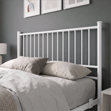 [White | Double] Metal bed close-up view of tall white bar headboard, layered neutral pillows, side rail and mattress stop.