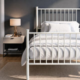 [White | Single] Metal bed close up view of bar headboard and footboard, white-grey bedding, lamp, books and silver decor.