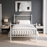 [White | Single] Front view of vertical iron bed with white-grey bedding, bar ends, centre leg, wall art, lamp & alarm clock.